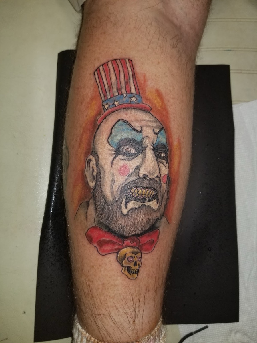 Color horror clown portrait tattoo on the lower leg