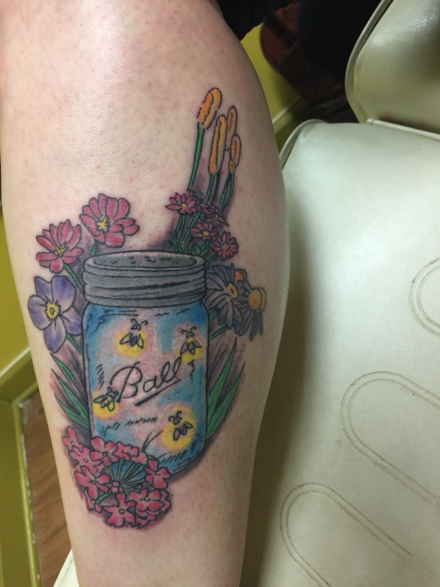 Color tattoo of a Ball mason jar with fireflies and wildflowers